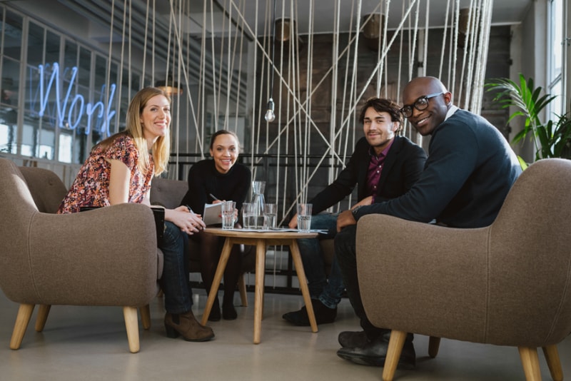 Fall and Winter Care for Commercial Rooftop Units. Image is a photograph of 4 coworkers sitting in an office lobby.